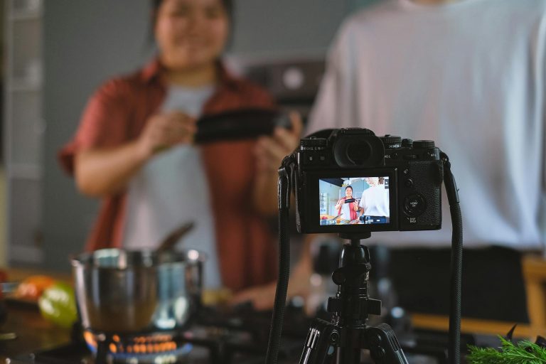 Behind-the-scenes setup of cooking video using a tripod-mounted camera in a kitchen.