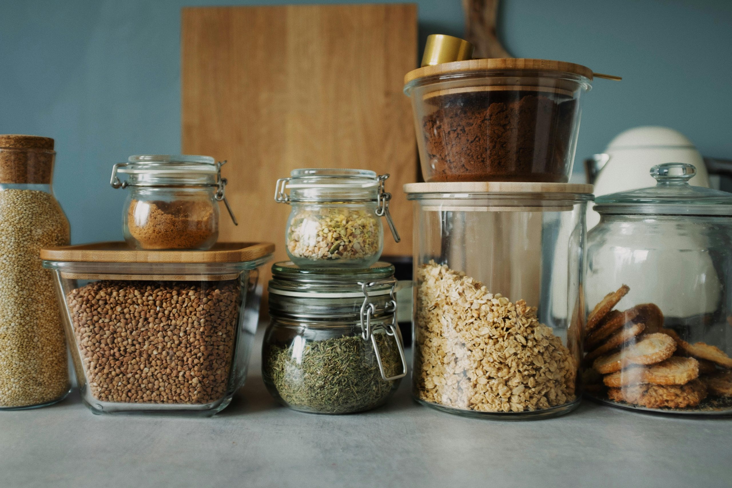 Stylish pantry setup with a variety of foods in glass storage jars, showcasing dry goods and cookies.